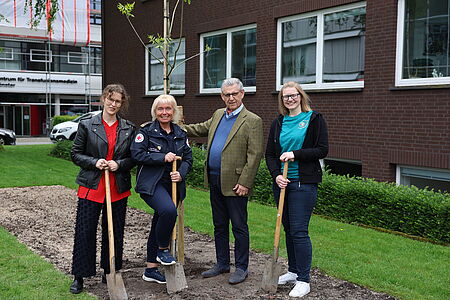 Mit dem neu gepflanzten Bienenbaum vor der DRK-Landesgeschäftsstelle in Münster: (von links) Laura Scheffelmaier (Klimaschutzmanagerin DRK-Landesverband Westfalen-Lippe), Tanja Knopp (Landesrotkreuzleiterin), Dr. Fritz Baur (Präsident DRK-Landesverband Westfalen-Lippe) und Andrea Büscher (Jugendrotkreuz-Landesleiterin)